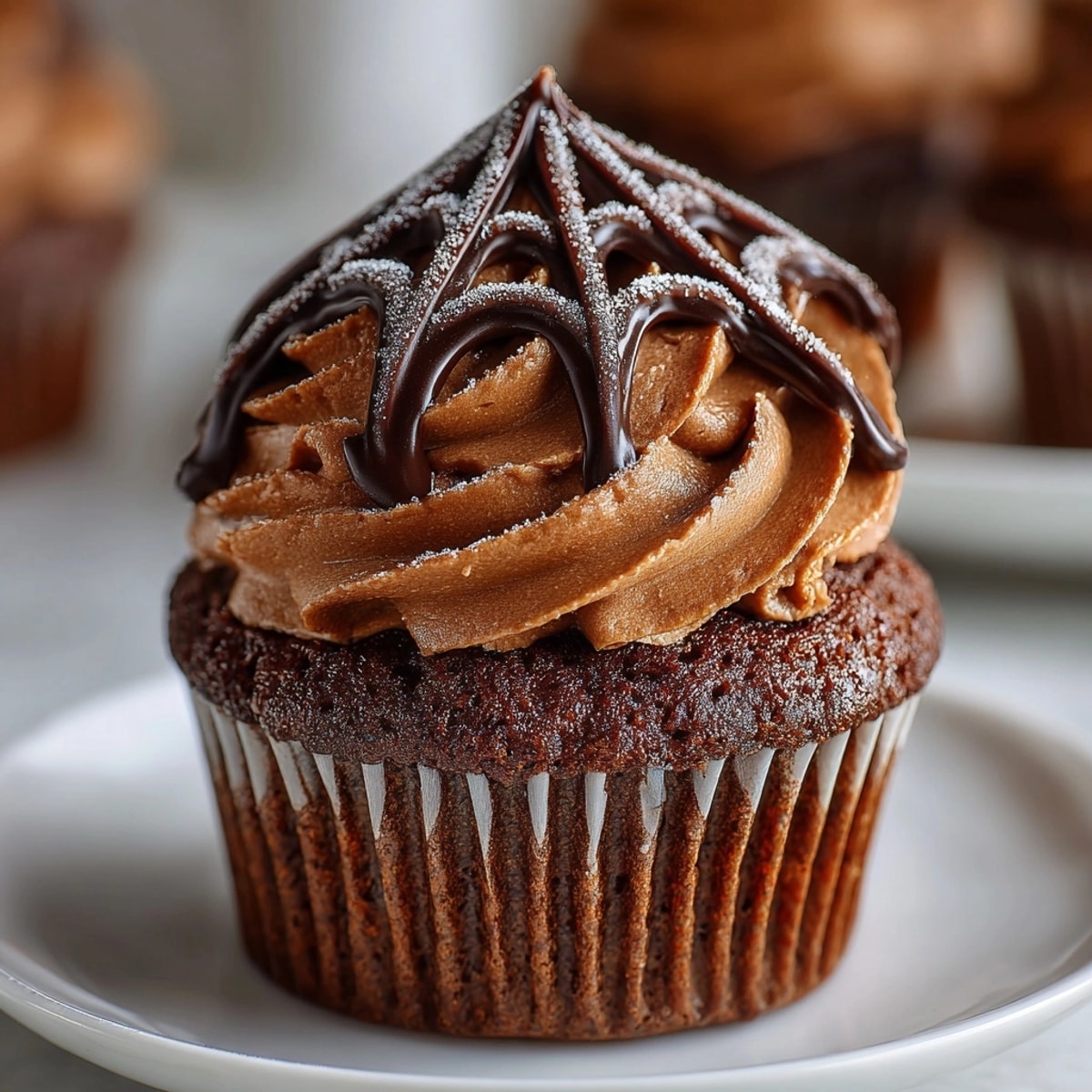 Close-up of Spider Web Cupcakes–chocolaty, sweet, with a spooky homemade marshmallow web on top.