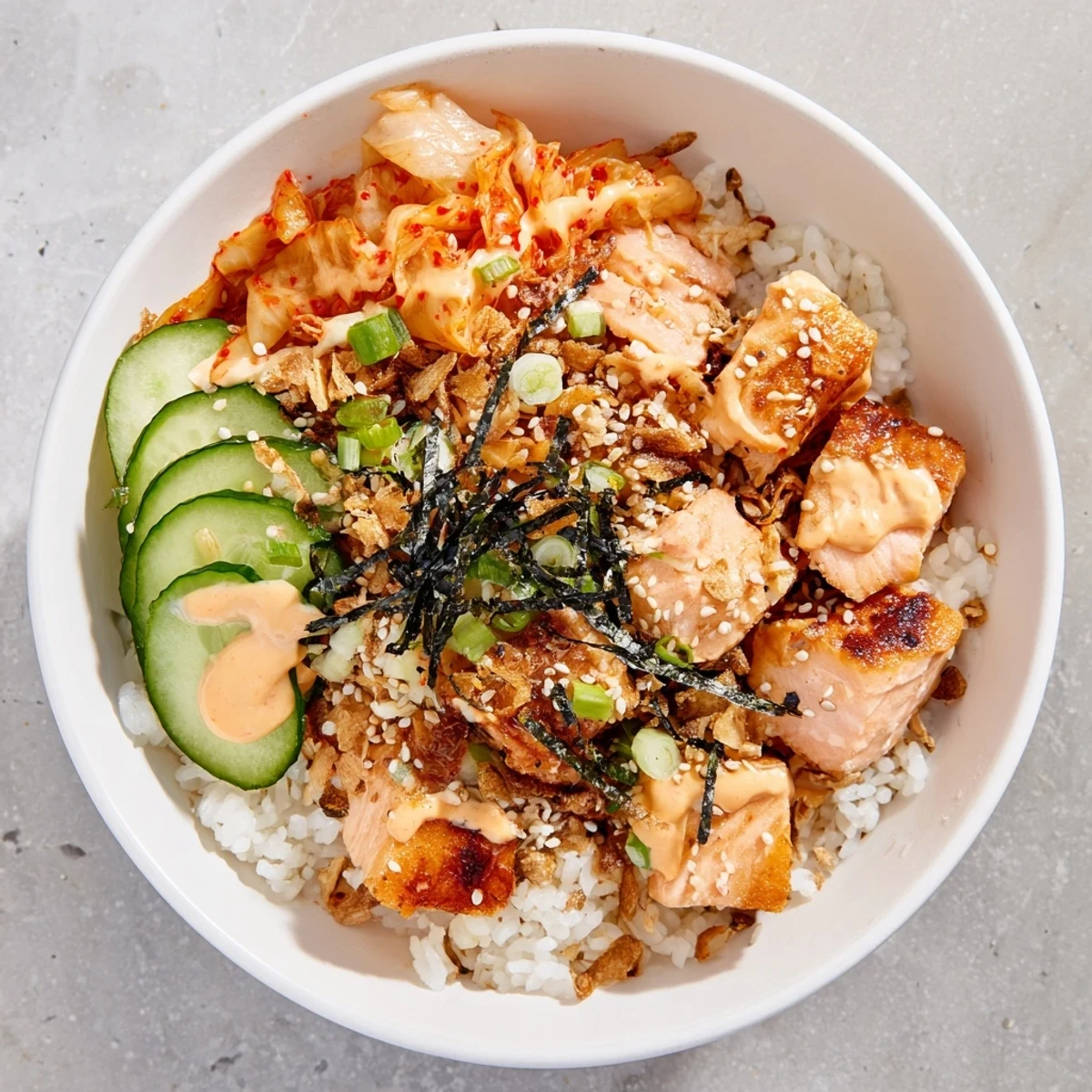 Savory Crispy Salmon Rice Bowl with crunchy vegetables and a drizzle of spicy mayo.