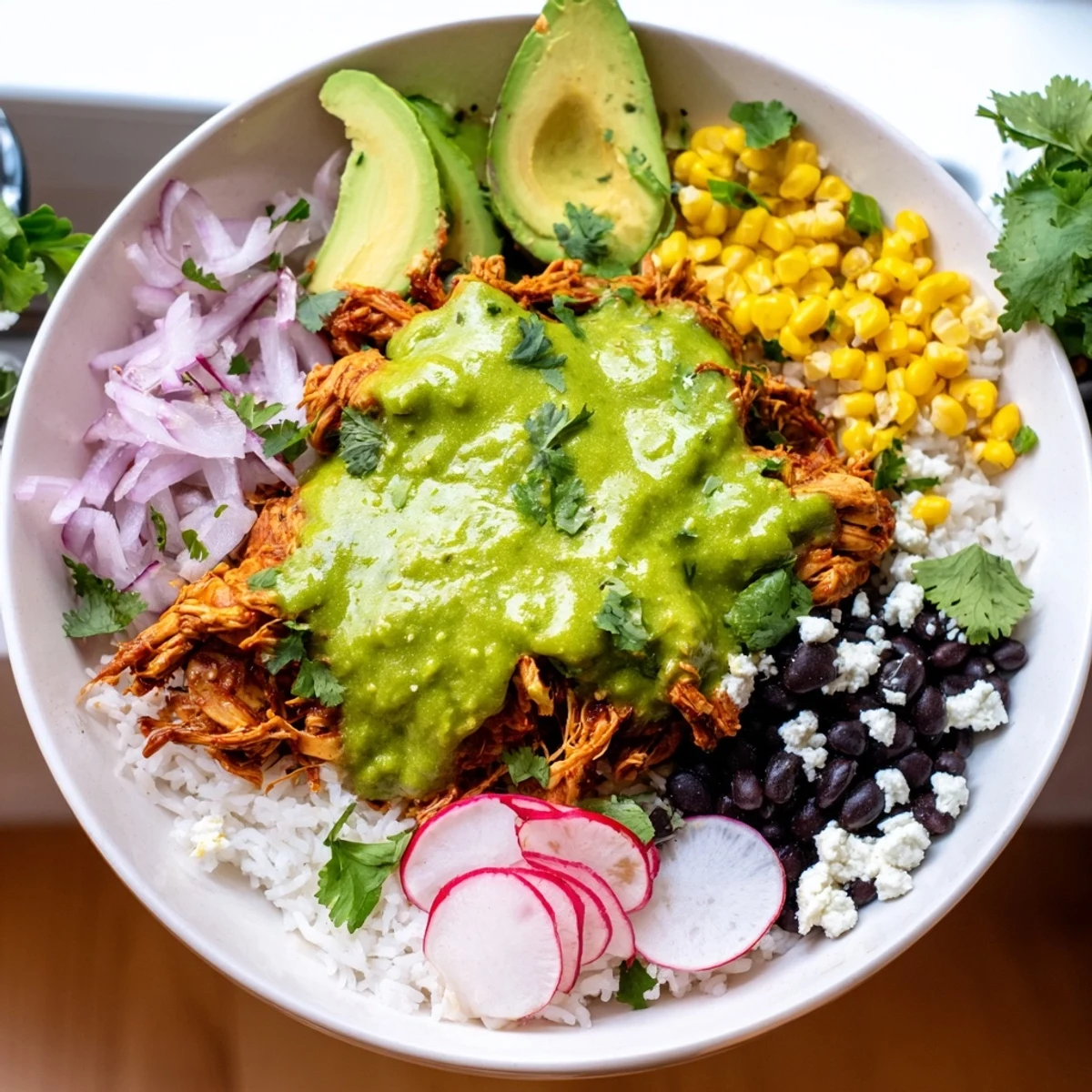 Warm green enchilada chicken atop fluffy rice with colorful toppings; a delicious Green Enchiladas Rice Bowl.