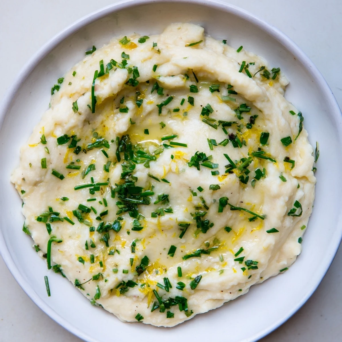 Fluffy cauliflower mash, infused with roasted garlic, a light and healthy alternative to mashed potatoes.