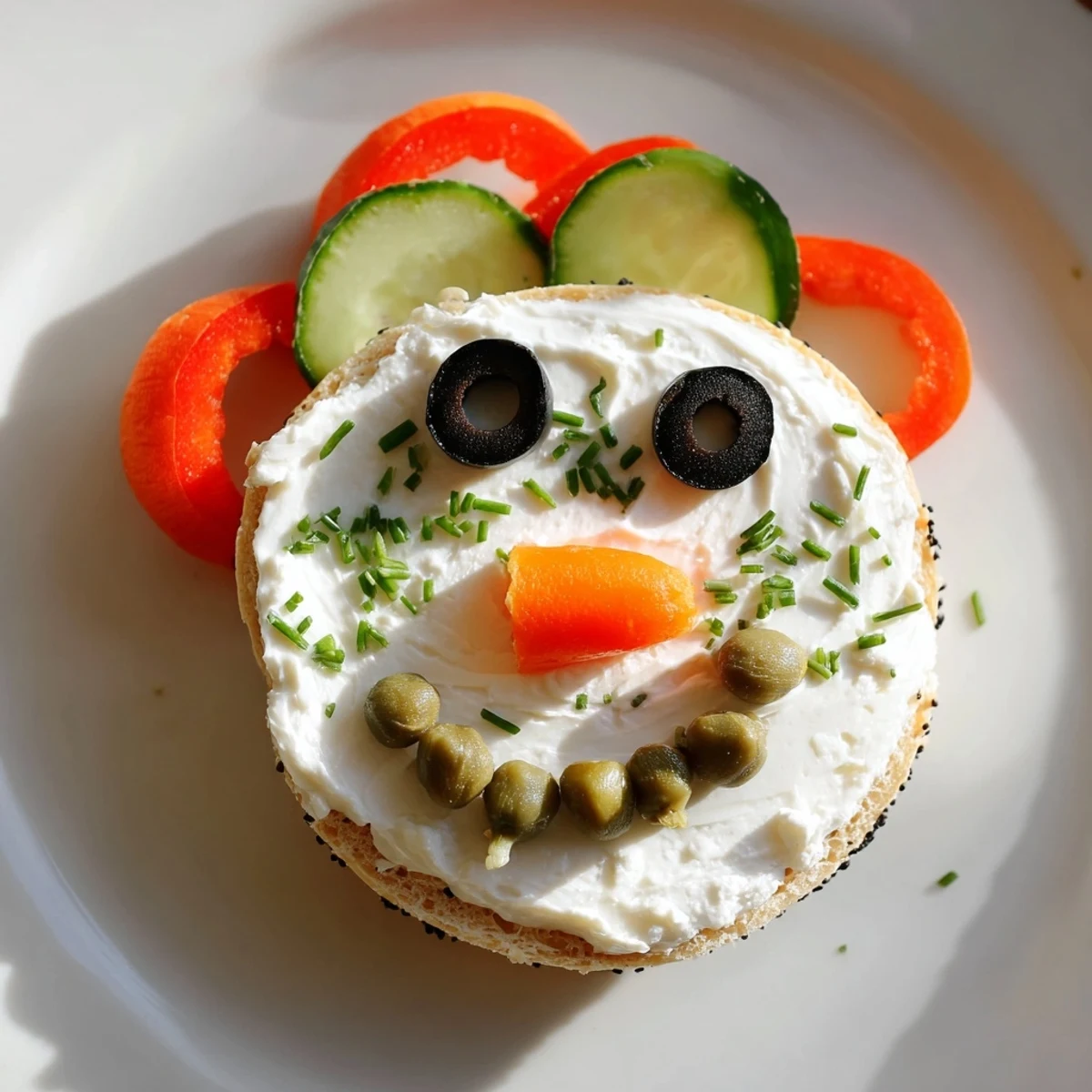 Snowman Mini Bagel Sandwiches featuring adorable snowman faces, complete with olive eyes and carrot noses.