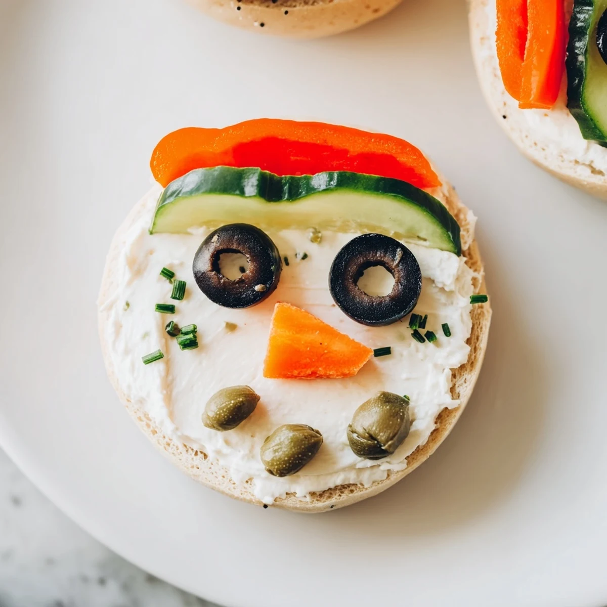 Festive Snowman Mini Bagel Sandwiches: creamy cream cheese bagels decorated into snowman lunch treats.