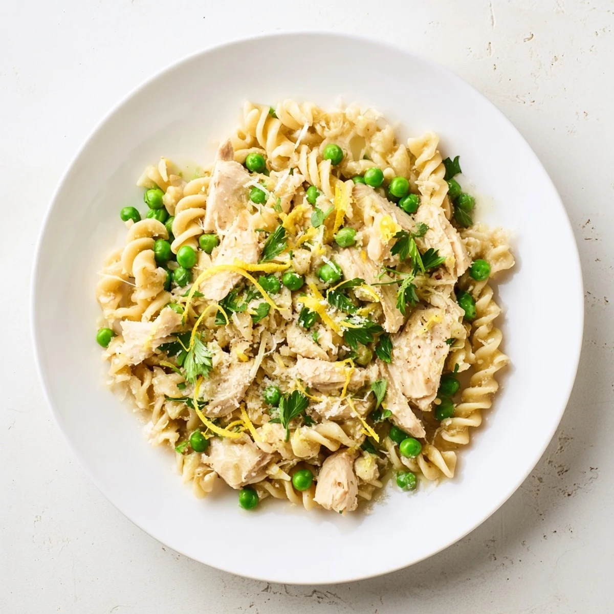 Golden chicken pieces, sweet green peas, and curly pasta coated in rich, fragrant garlic butter sauce.