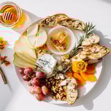 A beautifully arranged Honeycomb, Honey & Cheese Board ready for a delicious appetizer, including Brie.