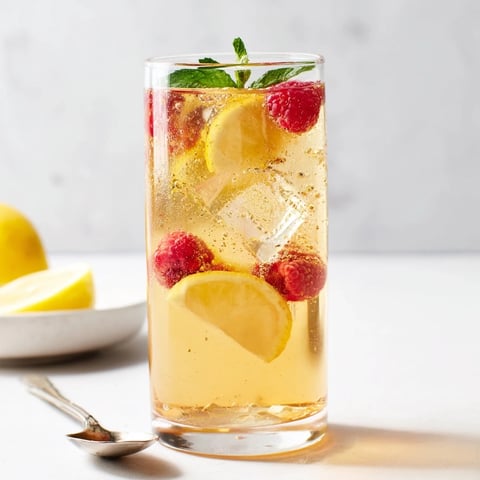 Refreshing kombucha-style home-brew mocktails garnished with fresh fruits and herbs.  