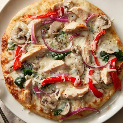 Golden Alfredo Chicken Veggie Pizza with vibrant toppings, hot from the oven and ready to slice.
