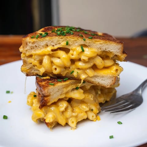 Buttery Mac and Cheese Stuffed French Toast, crisped golden brown, garnished with fresh chives.