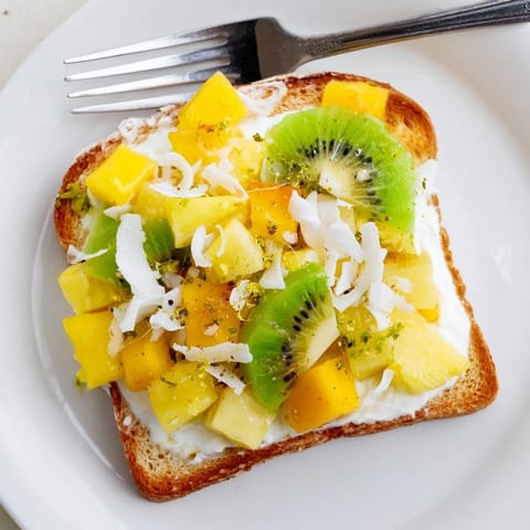 Golden brioche slices filled with coconut yogurt and fresh tropical fruits, perfect for brunch.  
