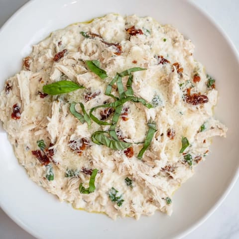A warm, flavorful bowl of Lightened Marry Me Chicken Dip, ready to be scooped up with crackers.