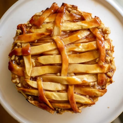 Crisp, golden brown lattice top of The Lattice Orchard over a sweet honey-nut filling, ready to serve this dessert.