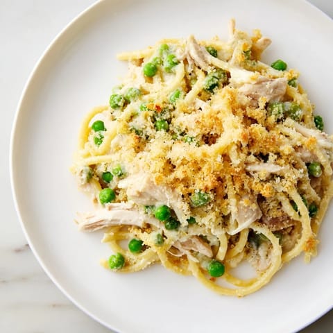 A steaming bowl of comforting Turkey/Chicken Tetrazzini Bake, showcasing the delicious, cheesy pasta layers.