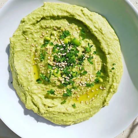 Freshly made Edamame Hummus, perfect for dipping, accompanied by colorful raw vegetables ready to enjoy.