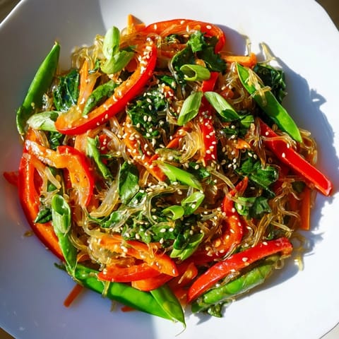 Crisp kelp noodles, snap peas, and carrots in a Kelp Noodle Stir-Fry served with lime wedges.  