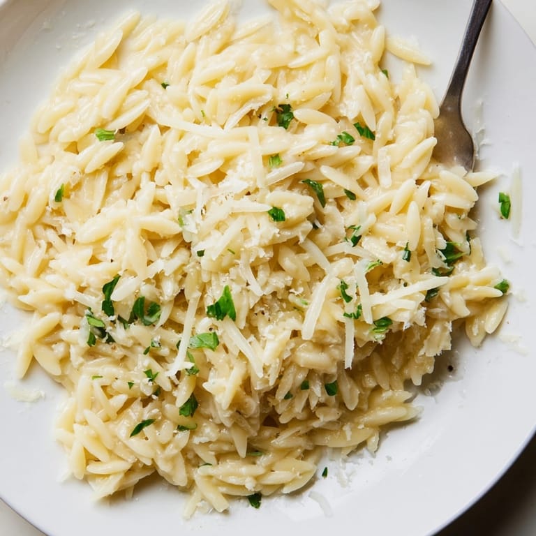 Overhead shot of Creamy Garlic Parmesan Orzo, garnished with parsley, ready to serve.