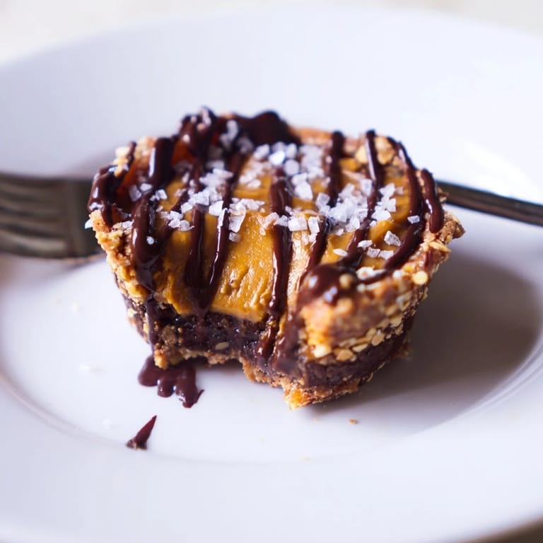 Mini pumpkin chocolate pretzel tartlets showcase a crunchy crust and rich filling bliss.  