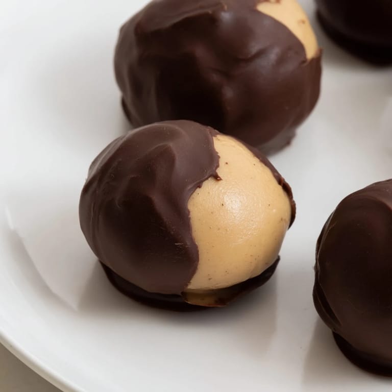 Close-up of freshly made peanut butter buckeyes, showcasing a sweet, homemade chocolate coating.