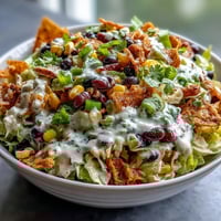 Fresh Frito Cowboy Cabbage salad with coleslaw mix, black beans, and corn tossed in smoky chipotle dressing in a rustic bowl.